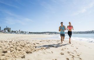 Ett par joggar längs stranden under sin viktnedgångsresa i Spanien