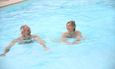 Man och kvinna njuter av en simtur i poolen
