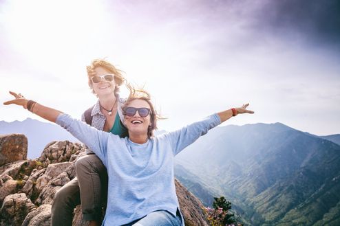 två lyckliga kvinnor på bergstoppen efter vandring på Mallorca