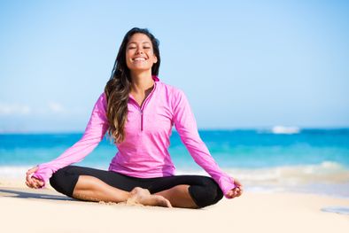 a woman heals emotionally by doing meditation on the beach