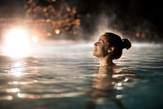 En kvinna badar i ett termiskt bad i Ungern på natten
